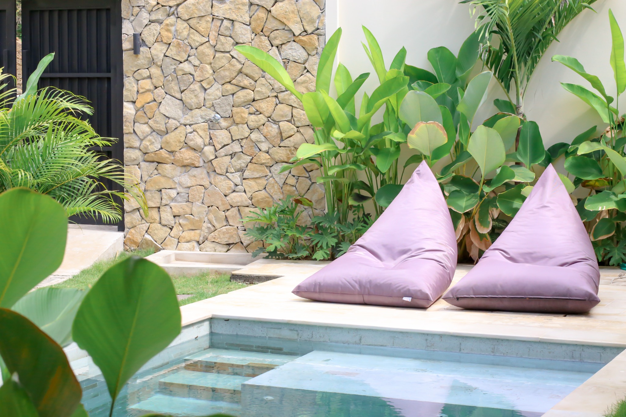 Pool loungers and stone outdoor shower